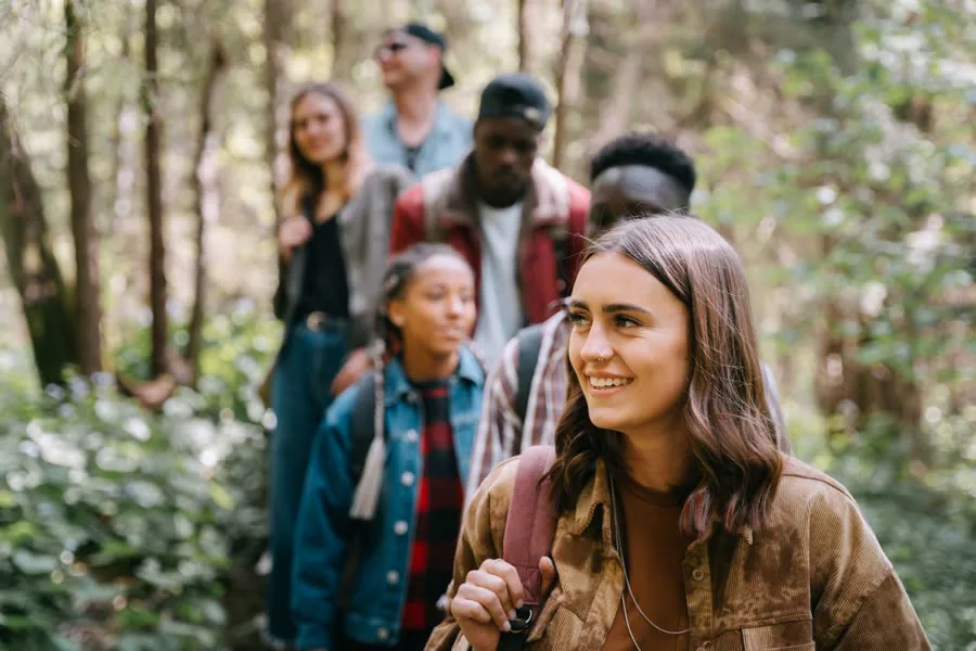 A smiling group of hikers on a forest trail